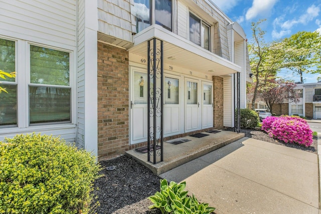 property entrance with brick siding and covered porch