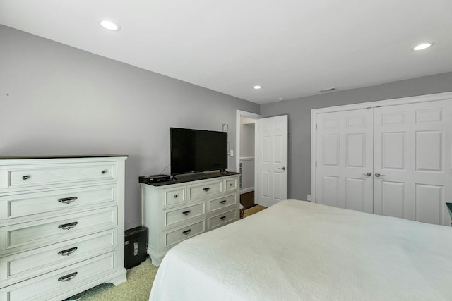 bedroom featuring a closet, recessed lighting, baseboards, and light colored carpet
