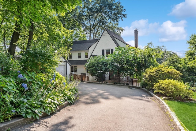 21 Judson Ave, Ardsley, NY 10502 - view of front of house with stucco siding, driveway, and a chimney