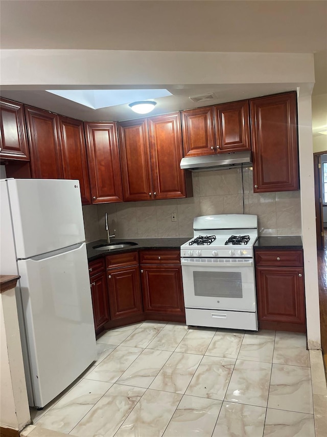 10615 155th St, Jamaica, NY 11433 - kitchen featuring white appliances, reddish brown cabinets, a sink, under cabinet range hood, and dark countertops