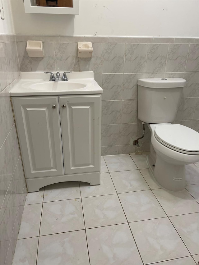 10615 155th St, Jamaica, NY 11433 - half bath with tile walls, vanity, toilet, a wainscoted wall, and tile patterned flooring