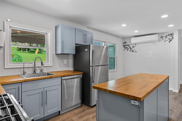15 Scanlon Ave, Florida, NY 10921 - kitchen featuring wood counters, stainless steel appliances, an AC wall unit, a sink, and light wood finished floors
