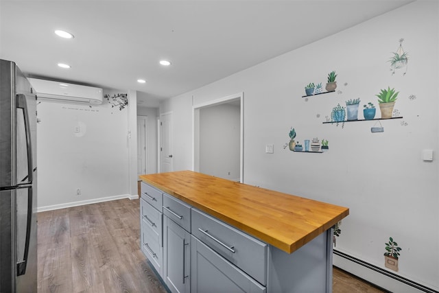 15 Scanlon Ave, Florida, NY 10921 - kitchen featuring freestanding refrigerator, a baseboard heating unit, a wall unit AC, butcher block countertops, and gray cabinetry