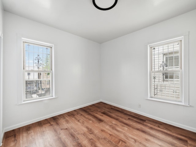 empty room with wood finished floors and baseboards