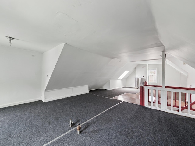 additional living space featuring carpet floors, lofted ceiling, and radiator heating unit
