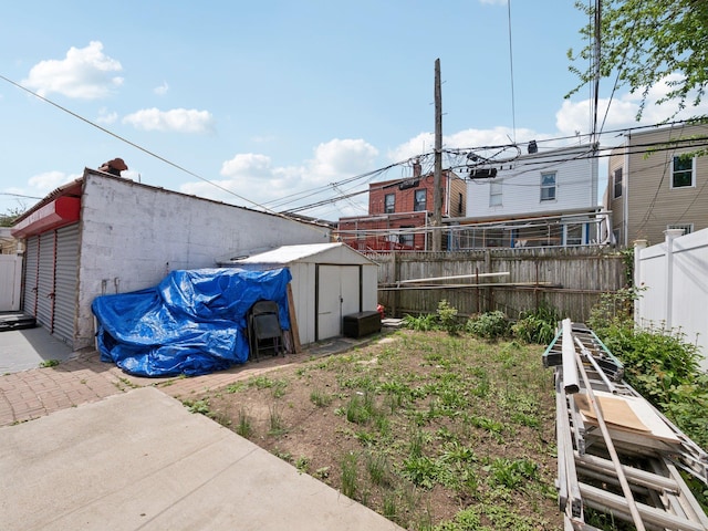 view of yard featuring a storage unit, an outbuilding, and fence