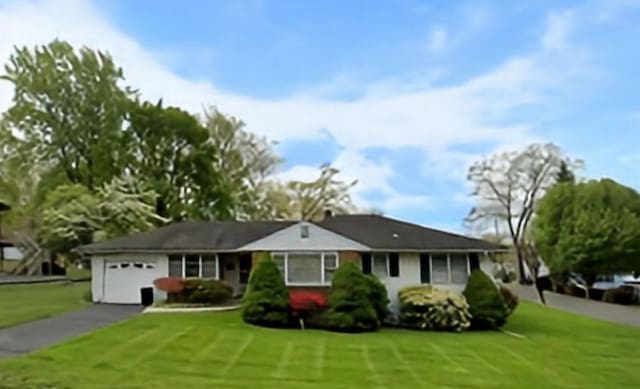 ranch-style house with a garage, driveway, and a front yard