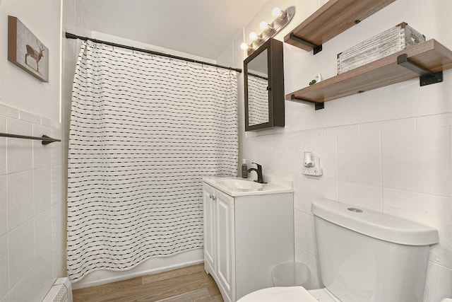 133 Spring Ln, Levittown, NY 11756 - full bathroom featuring tile walls, toilet, vanity, wood finished floors, and shower / bathtub combination with curtain