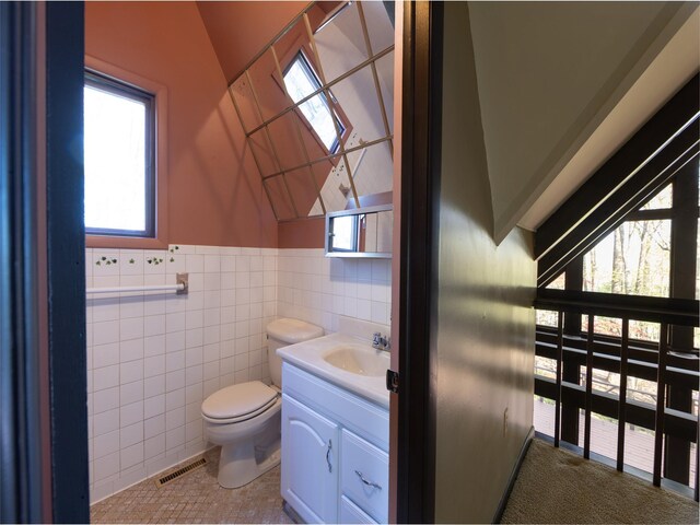 61 Reinhardt Rd, Middletown, NY 10940 - half bath with toilet, vanity, wainscoting, tile walls, and lofted ceiling