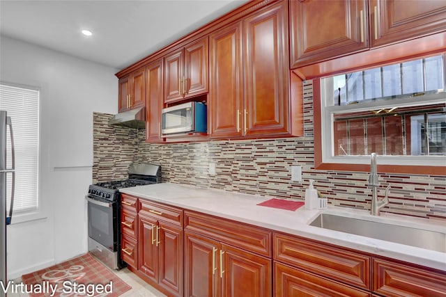 11511 173rd St, Addisleigh Park, NY 11434 - kitchen with appliances with stainless steel finishes, a sink, decorative backsplash, under cabinet range hood, and brown cabinets