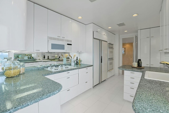 3333 Henry Hudson Pkwy # 23Ef, Bronx, NY 10463 - kitchen with white appliances, white cabinetry, light tile patterned floors, and recessed lighting