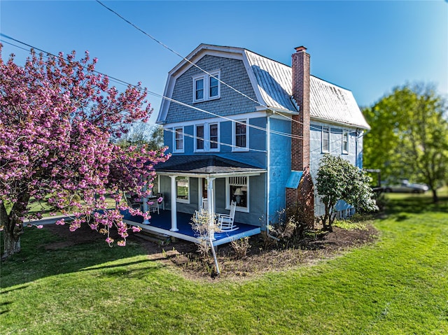 630 New Suffolk Rd, Cutchogue, NY 11935 - back of property featuring covered porch, a yard, a chimney, and brick siding