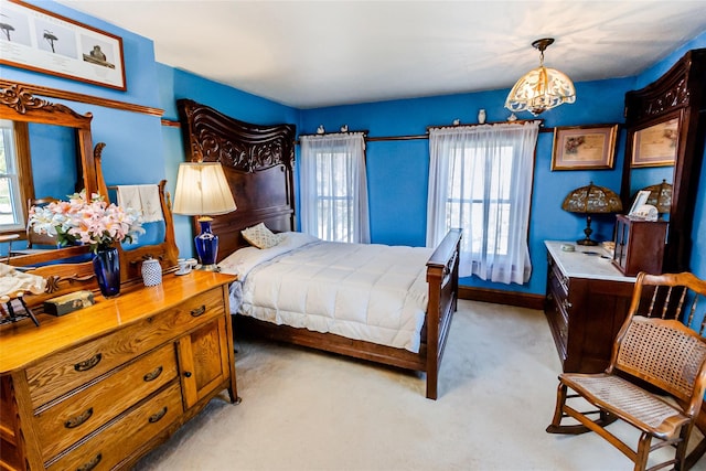 630 New Suffolk Rd, Cutchogue, NY 11935 - bedroom with a chandelier, multiple windows, light carpet, and baseboards