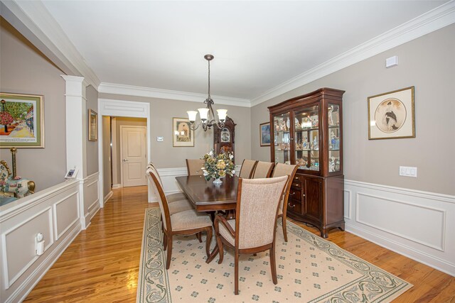 42 Kimberly Dr Unit 42, Westhampton, NY 11977 - dining area with light wood-style flooring, a chandelier, ornamental molding, a decorative wall, and a wainscoted wall