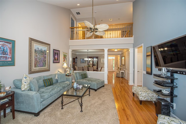 42 Kimberly Dr Unit 42, Westhampton, NY 11977 - living area featuring decorative columns, a high ceiling, light wood-type flooring, ceiling fan, and baseboards