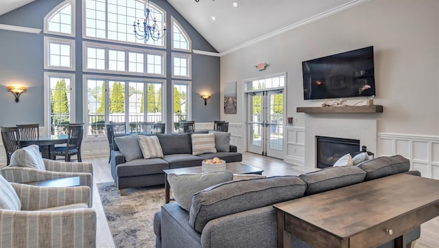 42 Kimberly Dr Unit 42, Westhampton, NY 11977 - living area featuring high vaulted ceiling, wood finished floors, french doors, a glass covered fireplace, and a decorative wall