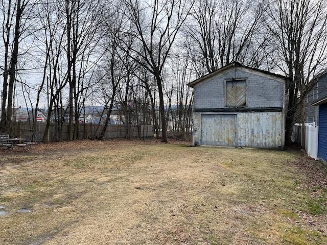 view of yard with a barn, fence, and an outdoor structure