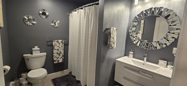 bathroom featuring toilet, tile patterned flooring, vanity, and curtained shower