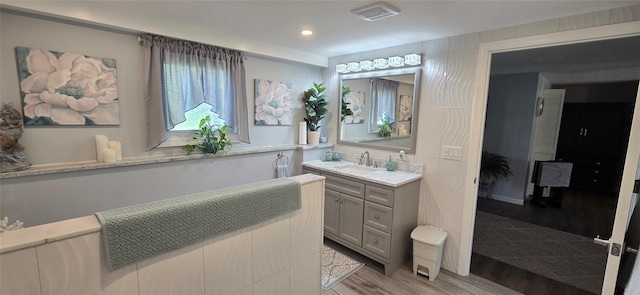 bathroom featuring wood finished floors, vanity, and recessed lighting