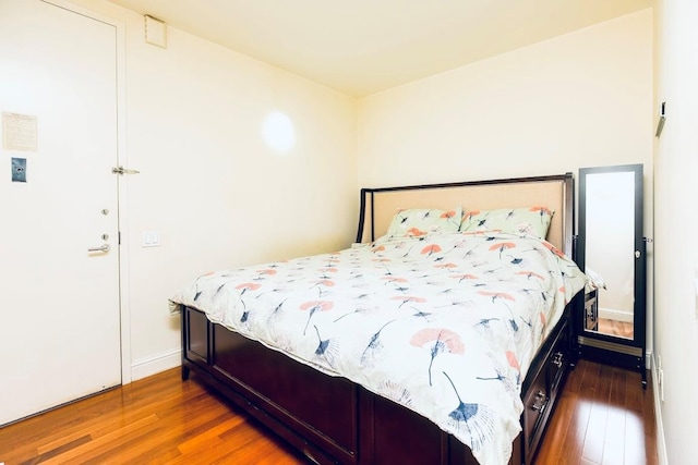 bedroom featuring hardwood / wood-style floors and baseboards