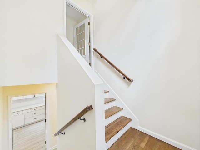 stairs featuring wood finished floors and baseboards