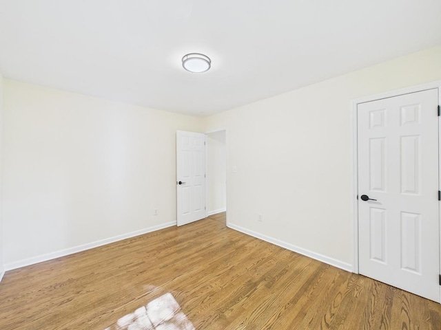 unfurnished room with light wood-style flooring and baseboards