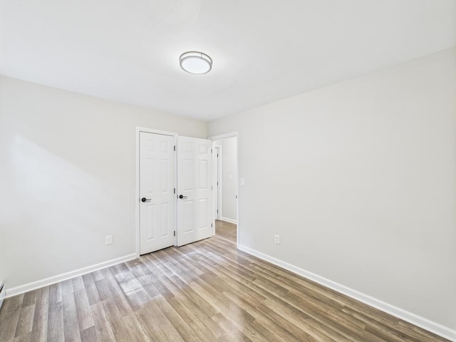 empty room with wood finished floors and baseboards