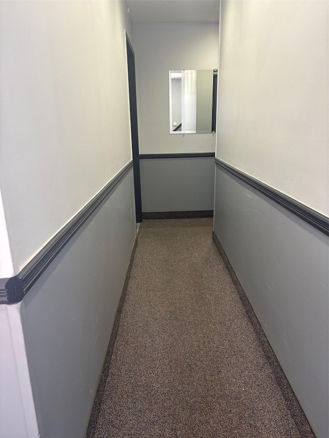 hallway featuring speckle patterned floor and baseboards