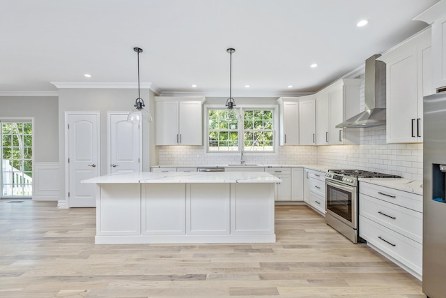 223 Townline Rd, Commack, NY 11725 - kitchen featuring appliances with stainless steel finishes, wall chimney exhaust hood, ornamental molding, a kitchen island, and white cabinetry