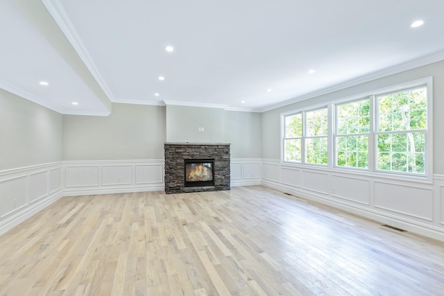 223 Townline Rd, Commack, NY 11725 - unfurnished living room with a decorative wall, ornamental molding, recessed lighting, light wood-style flooring, and a stone fireplace