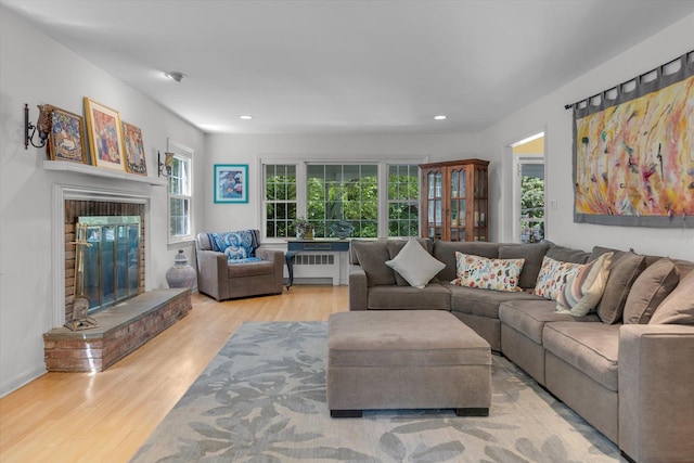 10 Bay Dr W, Huntington Bay, NY 11743 - living area with radiator heating unit, a brick fireplace, wood finished floors, and recessed lighting