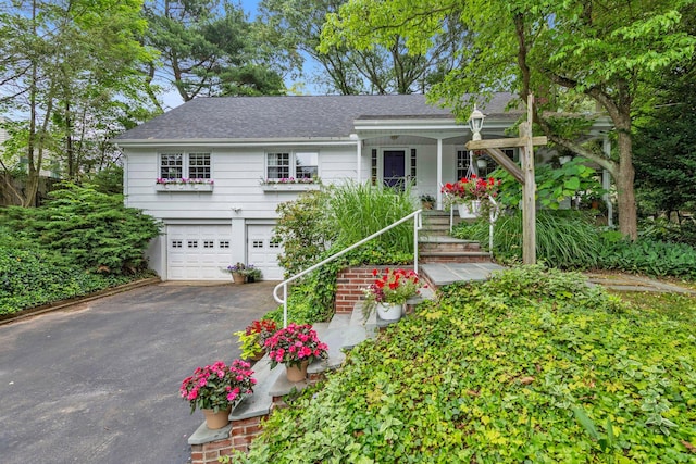 10 Bay Dr W, Huntington Bay, NY 11743 - view of front of house featuring driveway, an attached garage, a shingled roof, and covered porch