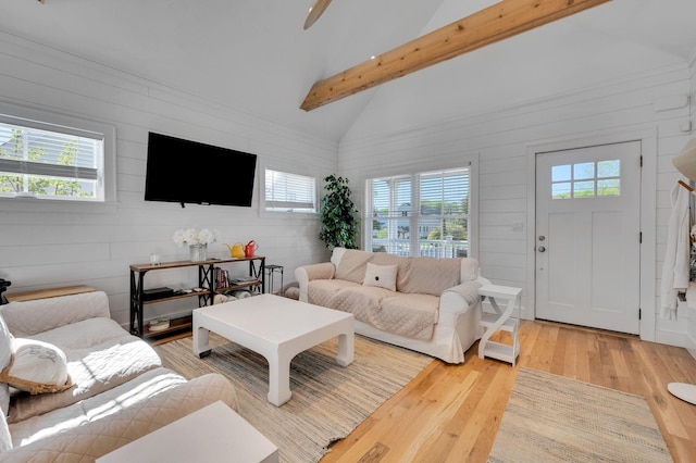 living area featuring light wood-type flooring and wooden walls