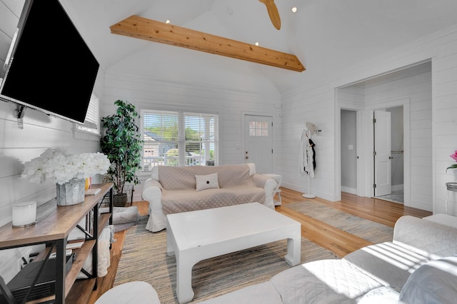 living room featuring light wood-style flooring, wooden walls, and baseboards