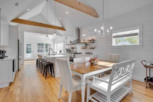 dining area featuring high vaulted ceiling, beamed ceiling, a chandelier, light wood-style floors, and recessed lighting