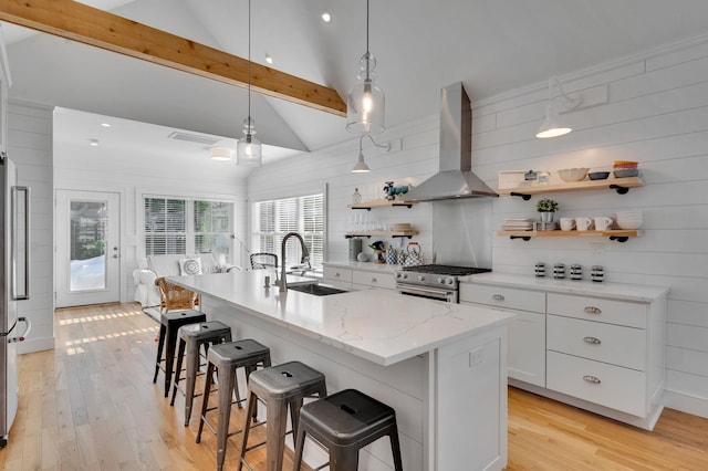 kitchen with a sink, open shelves, wall chimney exhaust hood, appliances with stainless steel finishes, and white cabinets