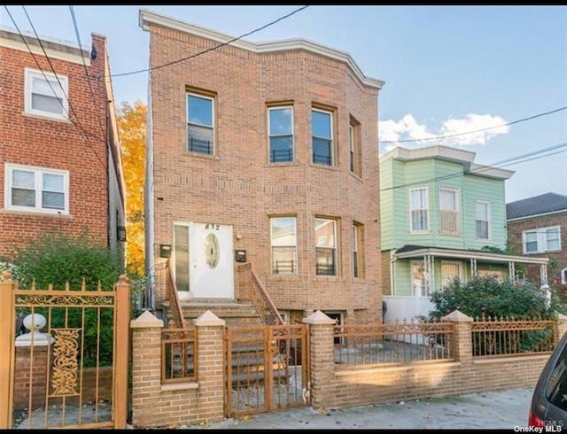 832 E 224th St, Bronx, NY 10466 - view of front facade with brick siding, a fenced front yard, and a gate