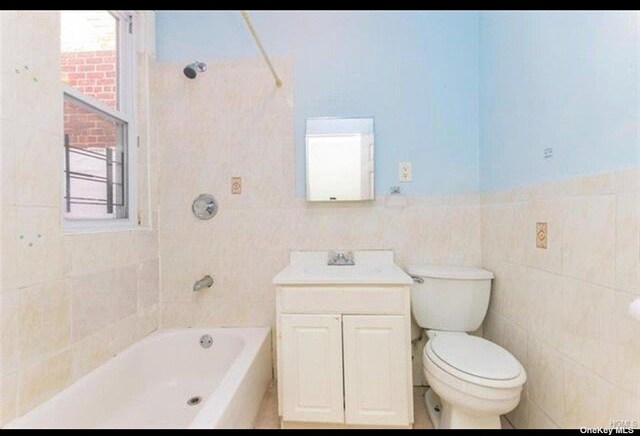 832 E 224th St, Bronx, NY 10466 - bathroom featuring tile walls, toilet,  shower combination, and vanity