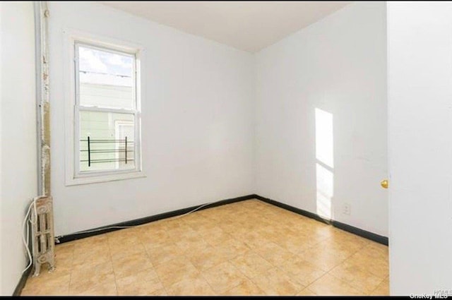 832 E 224th St, Bronx, NY 10466 - empty room featuring radiator heating unit and baseboards