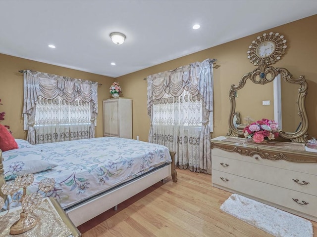 bedroom with light wood-style floors and recessed lighting