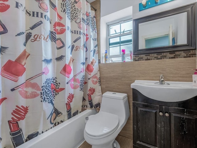bathroom featuring toilet, vanity, shower / bath combination with curtain, and decorative backsplash