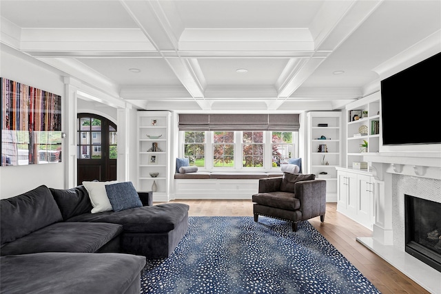 15 Wagamon Dr, Woodbury, NY 11797 - living area with healthy amount of natural light, wood finished floors, a fireplace with raised hearth, beamed ceiling, and ornamental molding