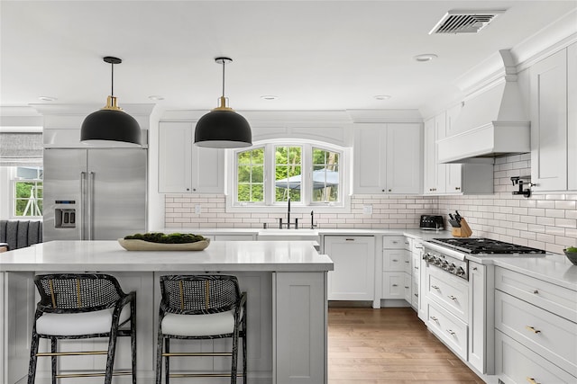 15 Wagamon Dr, Woodbury, NY 11797 - kitchen featuring stainless steel appliances, a sink, custom range hood, a breakfast bar, and recessed lighting