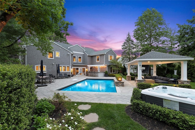 15 Wagamon Dr, Woodbury, NY 11797 - pool at dusk featuring an outdoor living space, a gazebo, a hot tub, and a patio