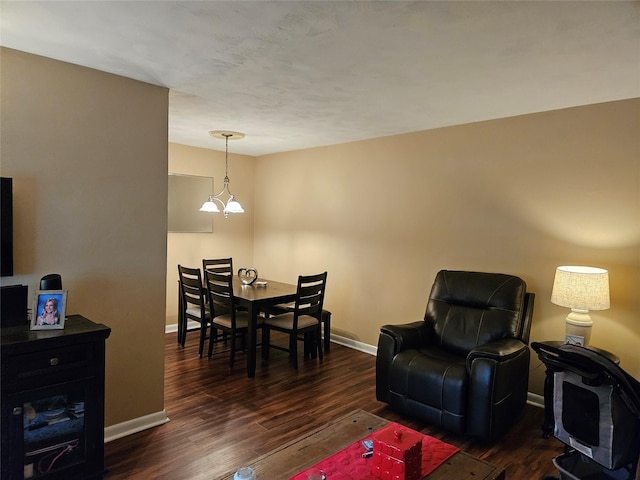 living room featuring baseboards, wood finished floors, and a chandelier