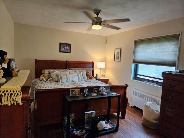 bedroom featuring radiator heating unit, wood finished floors, and ceiling fan