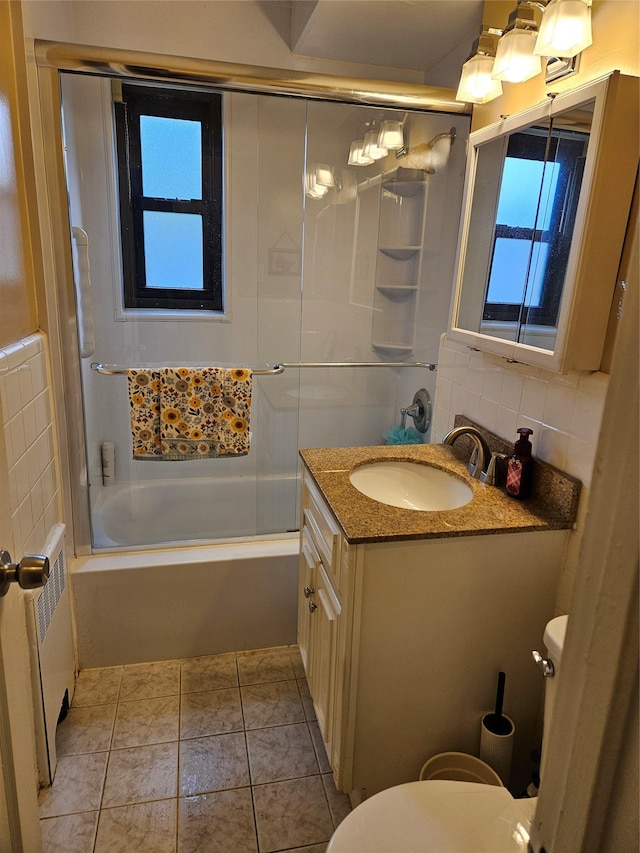 bathroom with radiator, toilet, shower / bath combination with glass door, and vanity