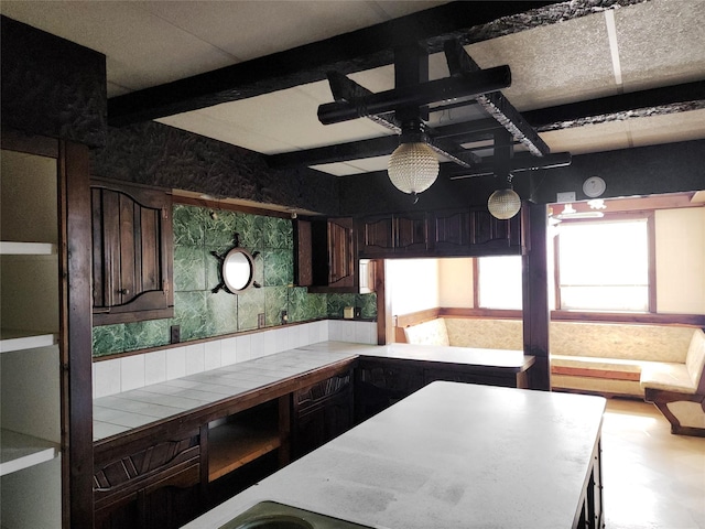 kitchen featuring tile counters, dark brown cabinetry, and a ceiling fan