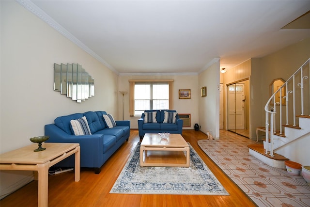 living room with wood finished floors, stairway, and ornamental molding