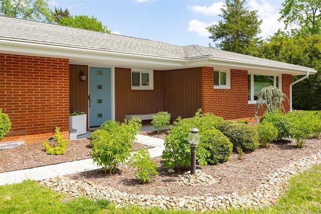 view of front of house featuring brick siding and a shingled roof
